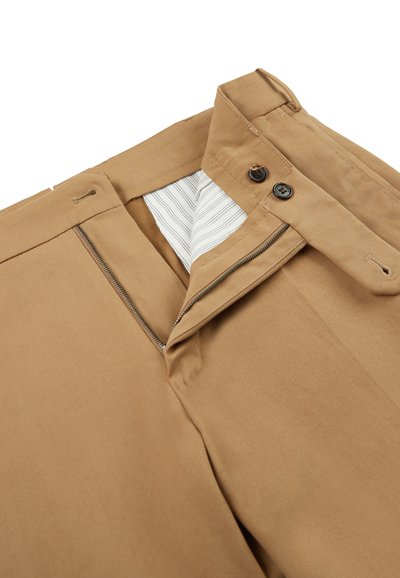 Pantalones de algodón en tono camel con cremallera y cierre de botón, y forro interior a rayas. Textura suave con bolsillos estándar y pasadores para cinturón.