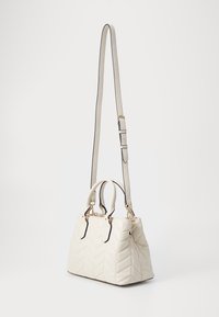 Gequilte witte handtas met een gestructureerd ontwerp, afgewerkt met zwarte accenten en gouden hardware. Beschikt over dubbele handgrepen en een afneembare schouderband.