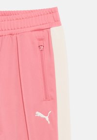 Ροζ αθλητικό παντελόνι με λευκή πλευρική ρίγα, ελαστική μέση, τσέπη με φερμουάρ και λευκό λογότυπο Puma στον αριστερό μηρό.