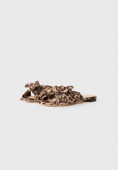 Sandale cu talpă plată, imitație de leopard, cu un superior din țesătură răsucită, design cu vârf deschis; prezintă o culoare bej deschis cu pete întunecate.