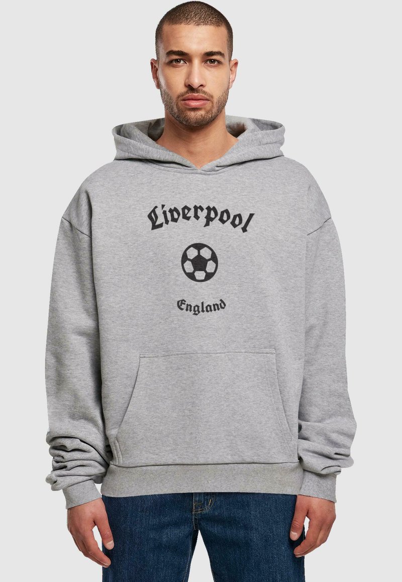 Grå hettegenser med lomme foran, med svart tekst som sier "Liverpool" og et fotballgrafikk. Uformell design, myk stoff.
