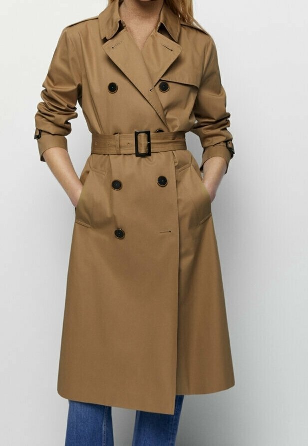 Tan trench coat in water-resistant fabric, features double-breasted buttons, belted waist, and front pockets, with wide lapels and a mid-length cut.