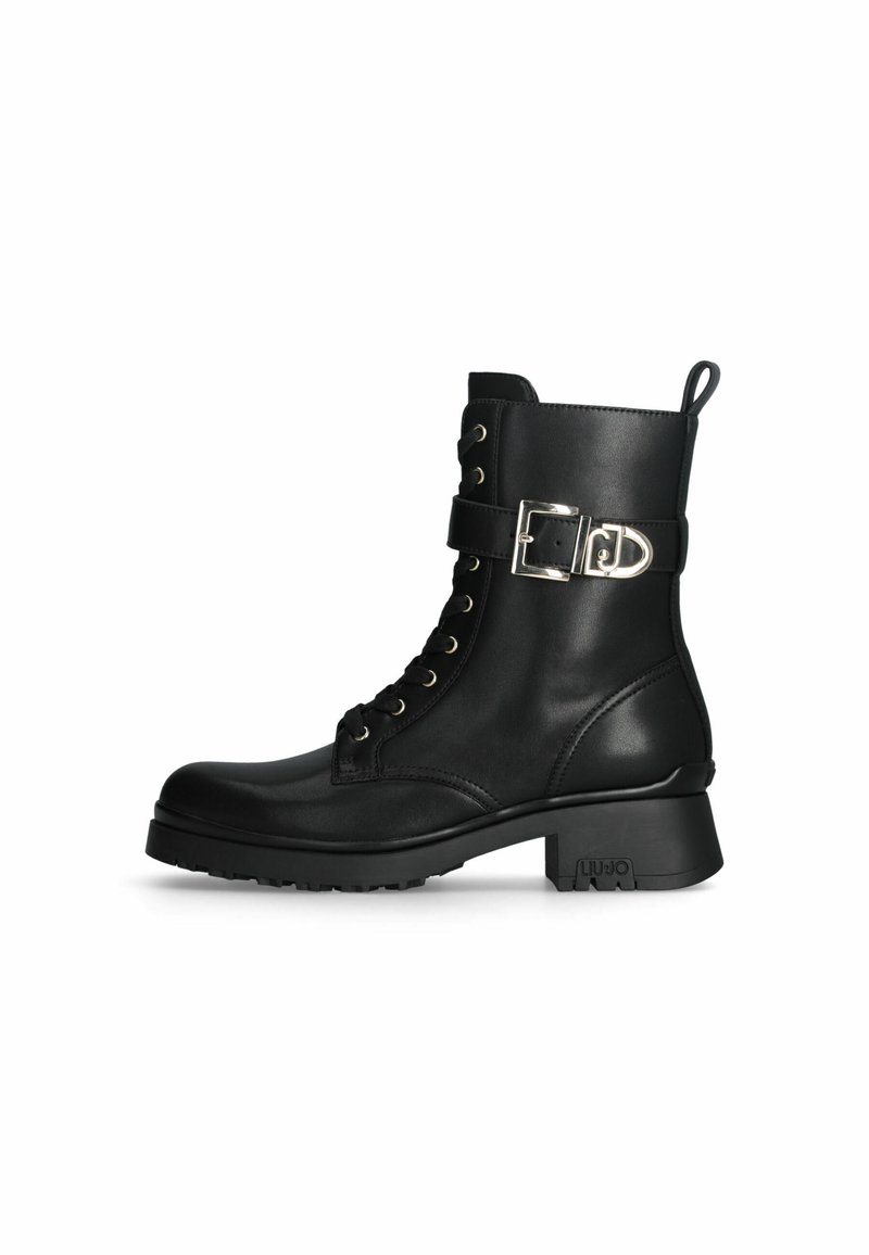 Stivaletto in pelle nera con lacci frontali, dettaglio in metallo argento e tacco texturizzato. Presenta una suola robusta per una migliore aderenza.