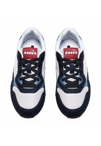 Sneakers in rete bianchi e sintetici blu navy con lacci neri. Presentano dettagli blu e un'etichetta rossa con logo. Punta tonda e suole imbottite.