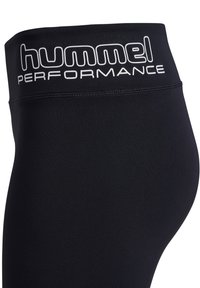 Close-up van zwarte leggings met hoge taille met het logo "hummel PERFORMANCE" in het wit op de tailleband gedrukt.
