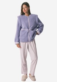Purple fluffy jacket with a tie waist, featuring a round neck and long sleeves. Paired with light striped pajama pants and beige slippers.