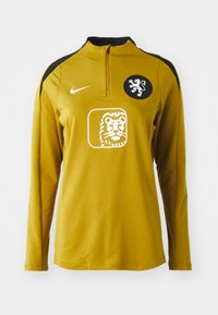 Yellow long-sleeve sports top with a quarter zip, black shoulder accents, a lion emblem on the chest, and Nike logo on the left shoulder.