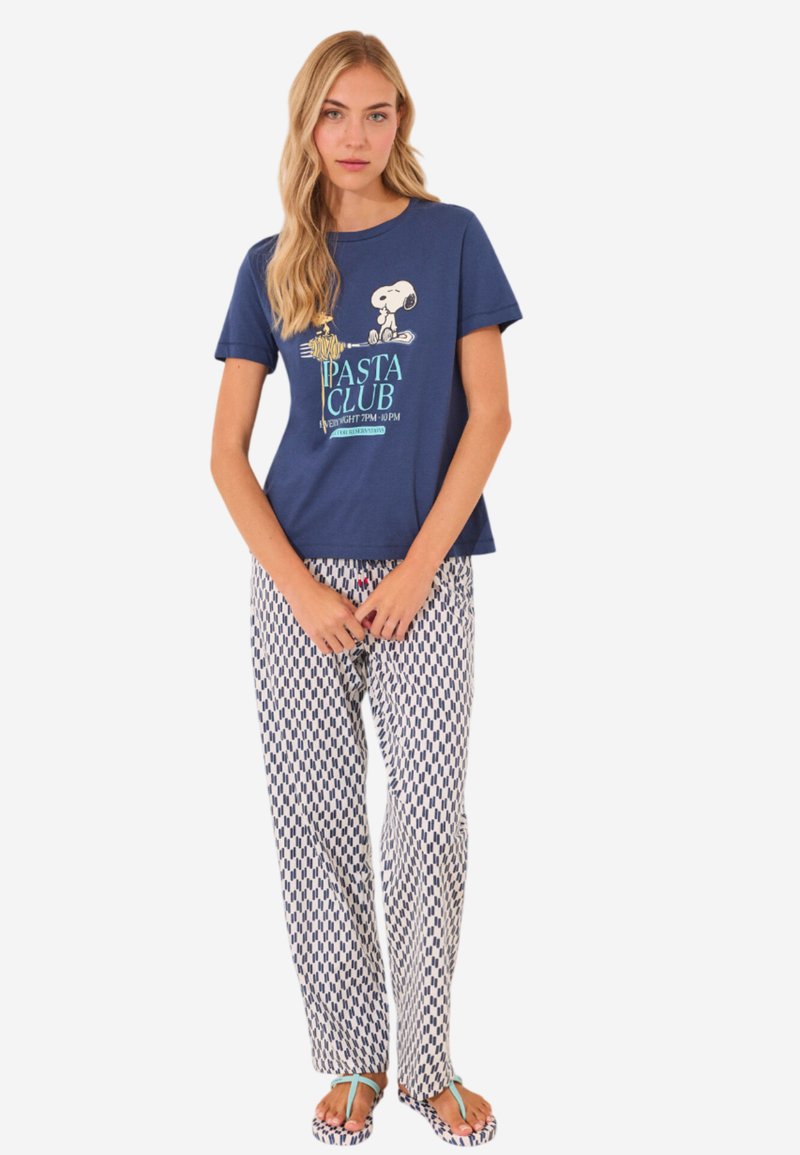Marineblauw T-shirt met "Pasta Club" graphic en Snoopy-ontwerp, gecombineerd met witte broek met een marineblauw geometrisch patroon. Inclusief slippers.