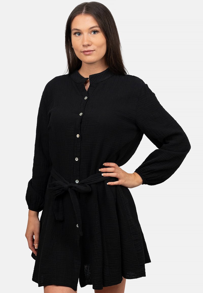 Abito nero con bottoni realizzato in tessuto testurizzato, con colletto, maniche lunghe e vita legata per una silhouette attillata.
