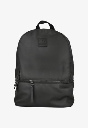 Mochila negra con asa superior, bolsillo delantero con cremallera y un pequeño parche de marca que dice "Xti Urban Brand" en la sección superior.