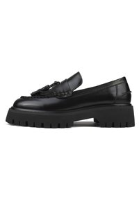 Černý kožený loafer s masivní podešví, který obsahuje dekorační třásničku a kontrastní prošívání na svršku. Hladká textura a elegantní design.