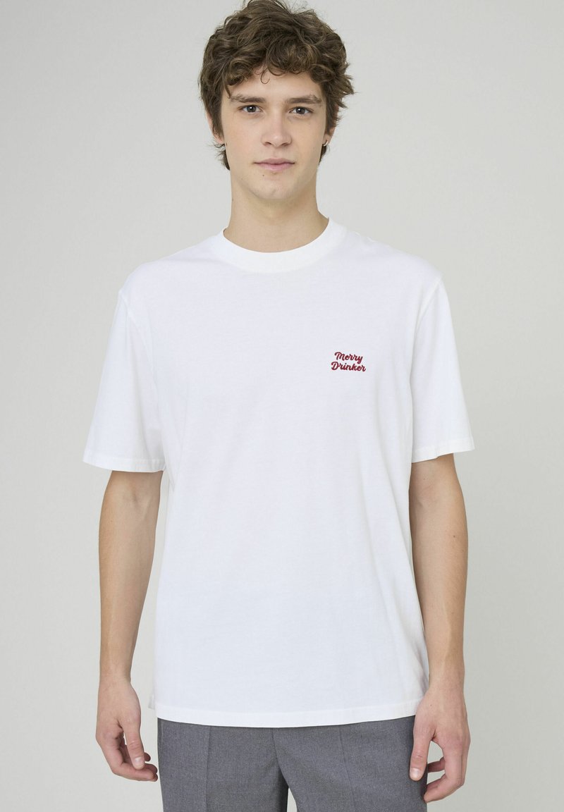 T-shirt en coton blanc avec "Merry Drinker" brodé en rouge, à manches courtes, coupe décontractée, col côtelé et texture lisse.