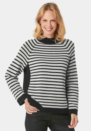 Maglione a righe bianco e nero, con colletto a coste, pannelli laterali neri a contrasto e una vestibilità rilassata con orlo diagonale.