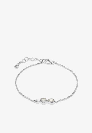 Bracelet délicat en chaîne d'argent avec trois charms centraux : petit cœur plein, cristal en forme de cœur et cristal en forme de goutte.