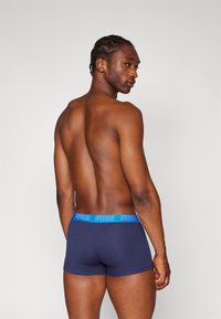 PUMA navyfarbene Boxershorts mit einem blauen Logo-Gummibund, aus einem figurschmeichelnden Design und einer glatten Textur für Komfort und Unterstützung.