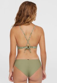 Bikini à motifs verts avec un dos croisé, des détails de lien ajustables et un tissu lisse. Le bas présente un design à taille haute en vert uni.