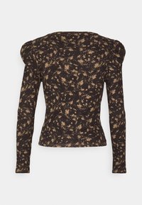 Pitkähihaisen, pussitettujen olkapäiden kanssa varustetun yläosan, jossa on musta ja vaalea ruskea abstrakti täpläkuvio.