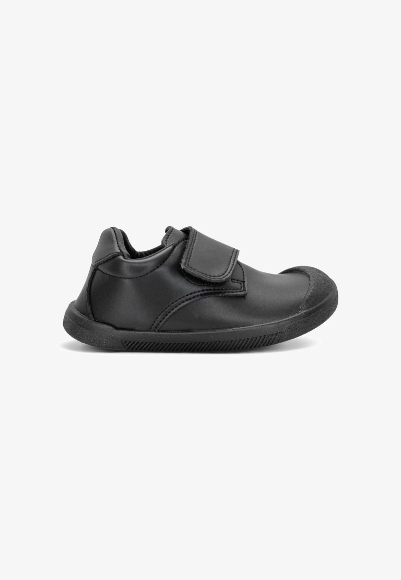 Chaussure noire pour enfants avec bride Velcro, embout renforcé et semelle en caoutchouc texturée vue de profil sur fond blanc.