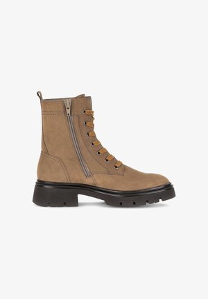 Braune Wildleder-Stiefeletten mit einer klobigen schwarzen Sohle, ausgestattet mit einem vorderen Schnürdesign und einem seitlichen Reißverschluss. Abgerundete Spitze und strapazierfähige Verarbeitung.