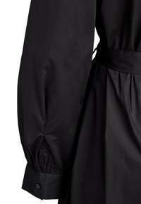 Schwarzes langärmliges Kleid mit gerafftem Bündchen und Knopfdetail, tailliertem Bund und plissiertem Rockteil.