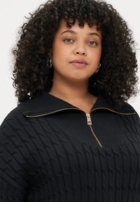 Čierny pletený sveter s káblovým vzorom, zipsovým golierom so zlatým kováním a jemne textúrovaným povrchom.