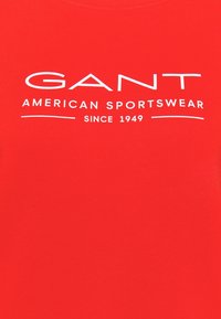Rood katoenen T-shirt met witte tekst "GANT AMERICAN SPORTSWEAR" en slogan "SINCE 1949". Zachte textuur, ronde hals, korte mouwen.