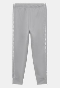 Light grey sweatpants with elastic waistband and white side stripes featuring small black triangle patterns.