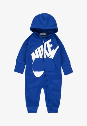 Blå heldragt med lynlås, lavet af blødt stof med hætte, der har en stor hvid Nike-logo på forsiden og en lomme foran.