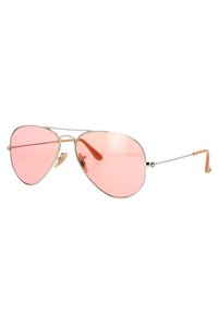 Occhiali da sole aviatore in metallo con lenti rosa, sottile montatura argentata e terminali in gomma di colore marrone chiaro per il comfort.