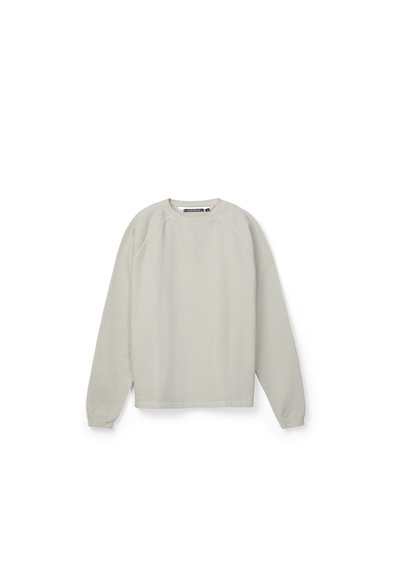 Sudadera gris claro de manga larga con cuello redondo, puños de canalé y un sutil logo de la marca en el pecho, presentada sobre un fondo blanco.