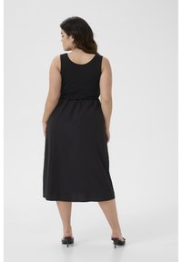 Zwarte mouwloze jurk met een aansluitende bodice en elastische tailleband, die doorloopt tot een zoom op de kuit; gladde textuur met een eenvoudig design.