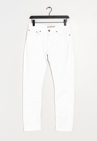 Jean slim blanc avec poches avant et fermeture à bouton, suspendu sur un cintre en plastique noir contre un fond blanc.