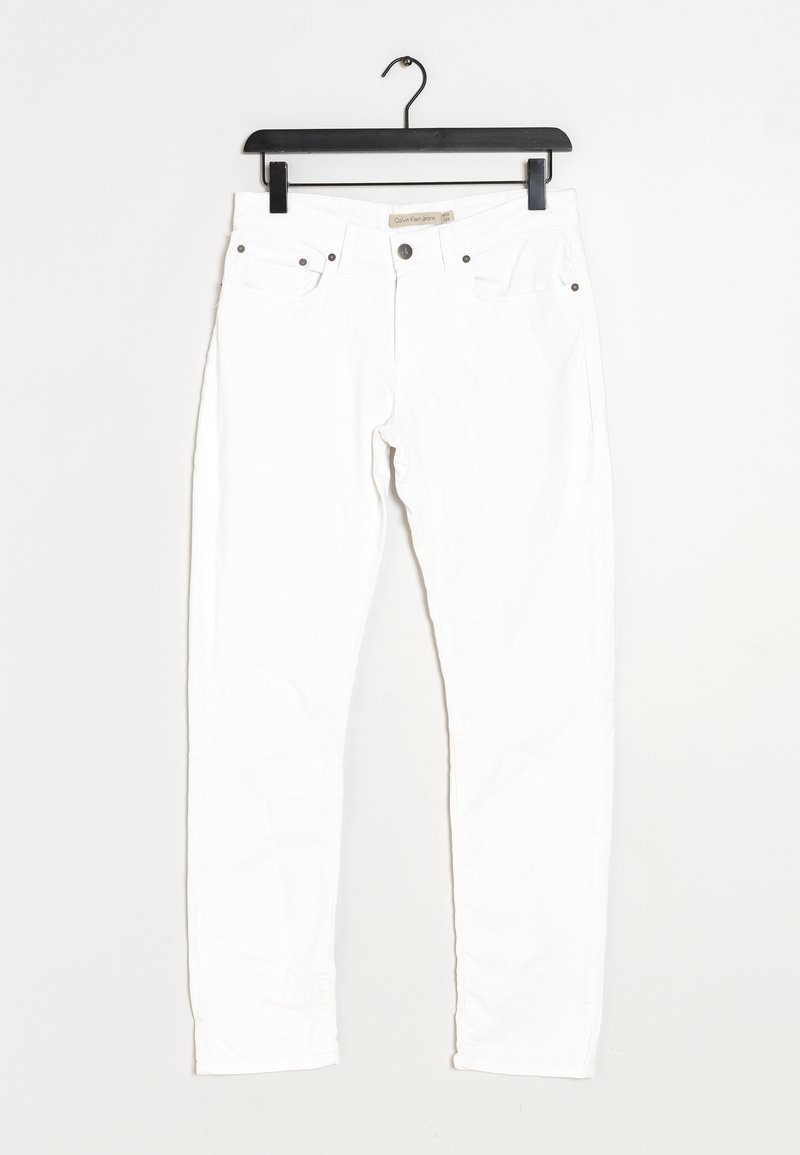 Jean slim blanc avec poches avant et fermeture à bouton, suspendu sur un cintre en plastique noir contre un fond blanc.