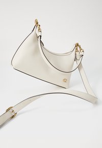 White leather handbag with a structured shape, gold hardware accents, and a contrasting dark trim. Includes an adjustable strap.