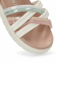 Sandalia blanca con suaves tiras elásticas en rosa, azul y beige en un diseño entrelazado. Suela gruesa para mayor comodidad.