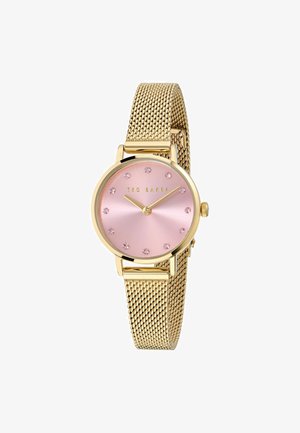 Reloj de malla dorado con una esfera rosa redonda, 12 marcadores de hora con cristales y manecillas doradas; presenta el nombre de la marca "TED BAKER" de manera prominente.