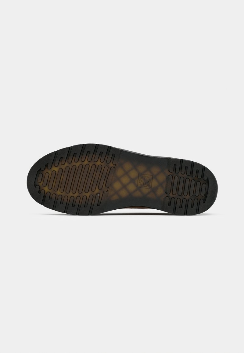 Semelle de chaussure en caoutchouc noir avec des motifs de grip texturés. Présente une légère arche et des bords arrondis, conçue pour l'adhérence et la durabilité.