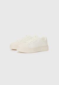 Witte sneakers met een gladde bovenkant, voorzien van een vetersluiting, ronde neus en een gestructureerde zool. Minimaal merkimago aan de zijkant.