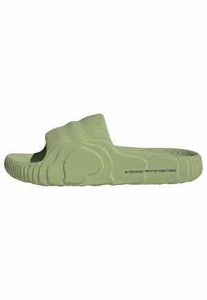 Jasnozielona sandałka typu slide z fakturowaną podeszwą i cholewką, z napisem „THE BRAND WITH THE THREE STRIPES" z boku.