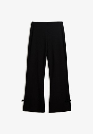 Sorte vide bukser lavet af et blødt stof, der har sidespalter fastgjort med sløjfer i kanten for ekstra detalje.