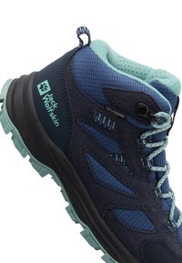 Dunkelblaue Wanderschuhe mit einer strukturierten Oberfläche, Mesh-Details, türkisfarbenen Akzenten und einer robusten Sohle mit einem ausgeprägten Profil.