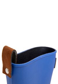 Blauer Gummstiefel mit einer geschwungenen Oberkante, ausgestattet mit einem braunen Wildledergurt und einem metallischen Druckknopf. Innen ist er mit schwarzem Material ausgekleidet.