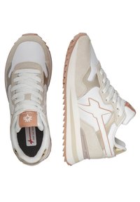 Scarpe sportive beige e bianche realizzate con materiali in suede e mesh, dotate di una suola in gomma, dettagli testurizzati e un design con lacci.