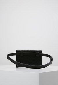 Borsa a tracolla in pelle nera con un motivo in pelle di serpente texturizzato, forma rettangolare, tracolla regolabile e dettagli hardware minimi.