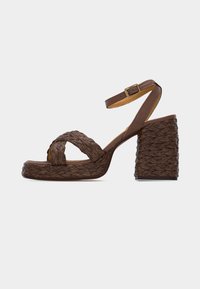 Καφέ πλεκτό πλατφόρμα σανδάλι με ψηλό τακούνι, λουράκι στον αστράγαλο και αγκράφα, με χοντρό τετράγωνο τακούνι και πλεγμένη υφή.