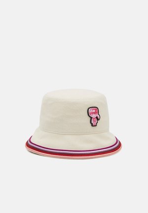 Beige bucket hat with pink, purple, and red striped brim and a small pink cartoon patch on the front side.