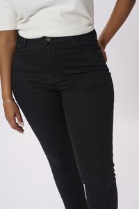 Jeans in denim nero con una silhouette aderente, dotati di chiusura con bottone, tasche frontali e una texture liscia.