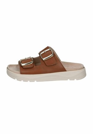 Brun læder slip-in sandal med to justerbare sølvspænder og tyk hvid sål, designet til afslappet brug.