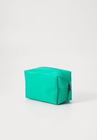 Grønn, rektangulær pose laget av glatt, slitesterkt materiale. Har en glidelås på toppen, med avrundede kanter og en flat bunn for stabilitet.