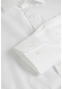 Witte overhemd met een klassieke kraag, knoopmanchetten, een gladde textuur en afgeronde knoopsluitingen. De stof lijkt fris en goed afgewerkt.